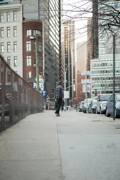 Figura trasera completa de un skateboarder navegando por la calle de la ciudad — Foto de Stock