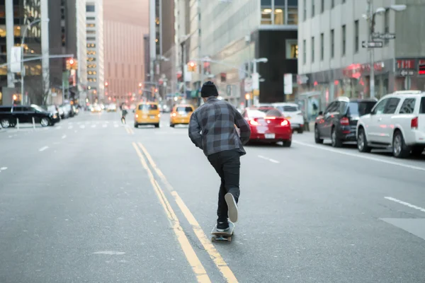 Figuur van jonge skateboarder cruisen naar beneden de straat stad terug — Stockfoto