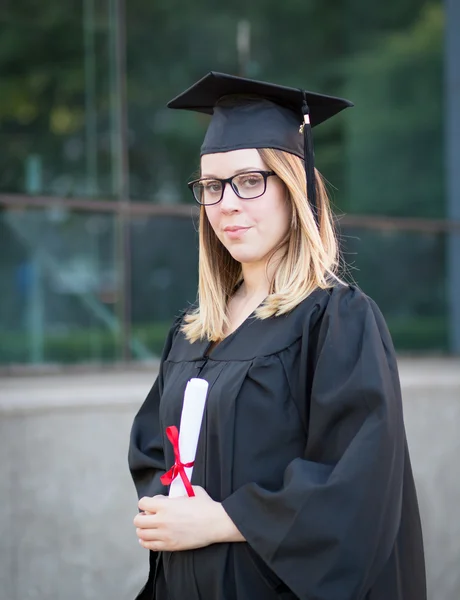 Porträtt av kvinnliga collegestudent med glas i examen da — Stockfoto