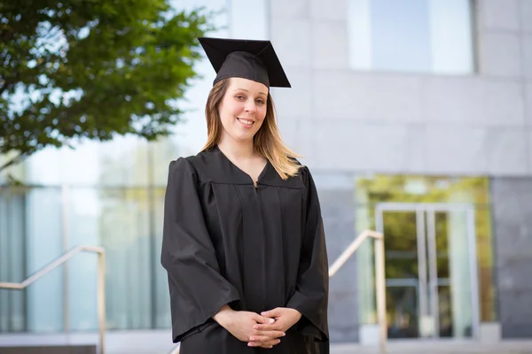 Portret van vrouwelijke student in afstuderen cap en toga op — Stockfoto