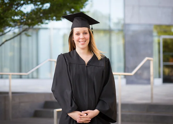 Portret van vrouwelijke student in afstuderen cap en toga op — Stockfoto