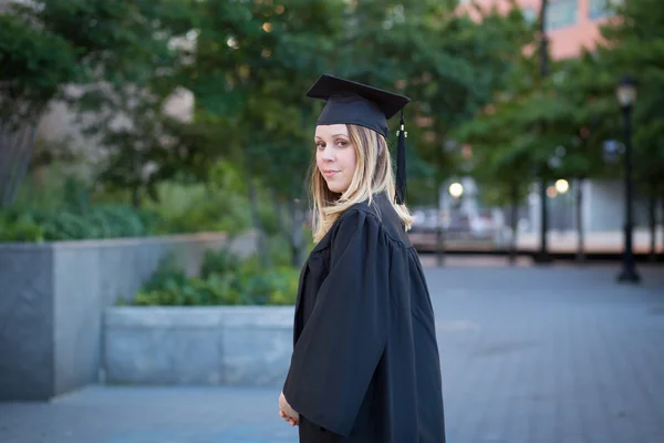 Retrato de una estudiante universitaria con gorra y vestido de graduación — Foto de Stock