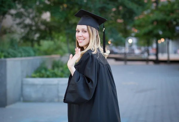 Estudiante saludando mano en la graduación en el campus universitario — Foto de Stock