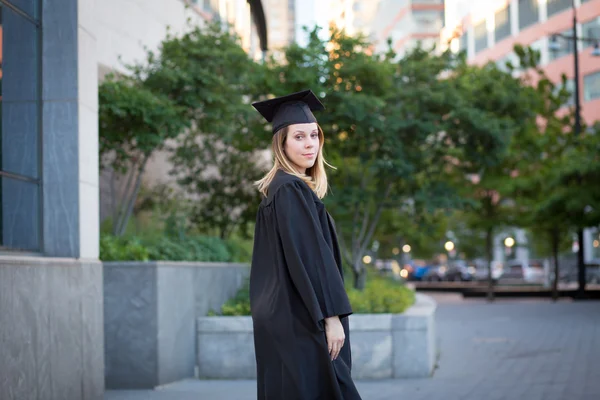 Portrét ženy studenta v odstupňování čepici a šaty na — Stock fotografie