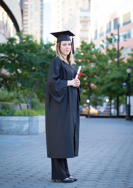 Retrato de estudante universitário feminino em boné de graduação e vestido ho — Fotografia de Stock