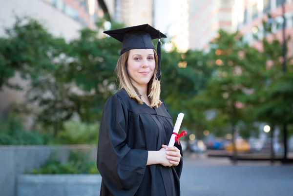 Ritratto di studentessa universitaria in berretto di laurea e abito ho — Foto Stock