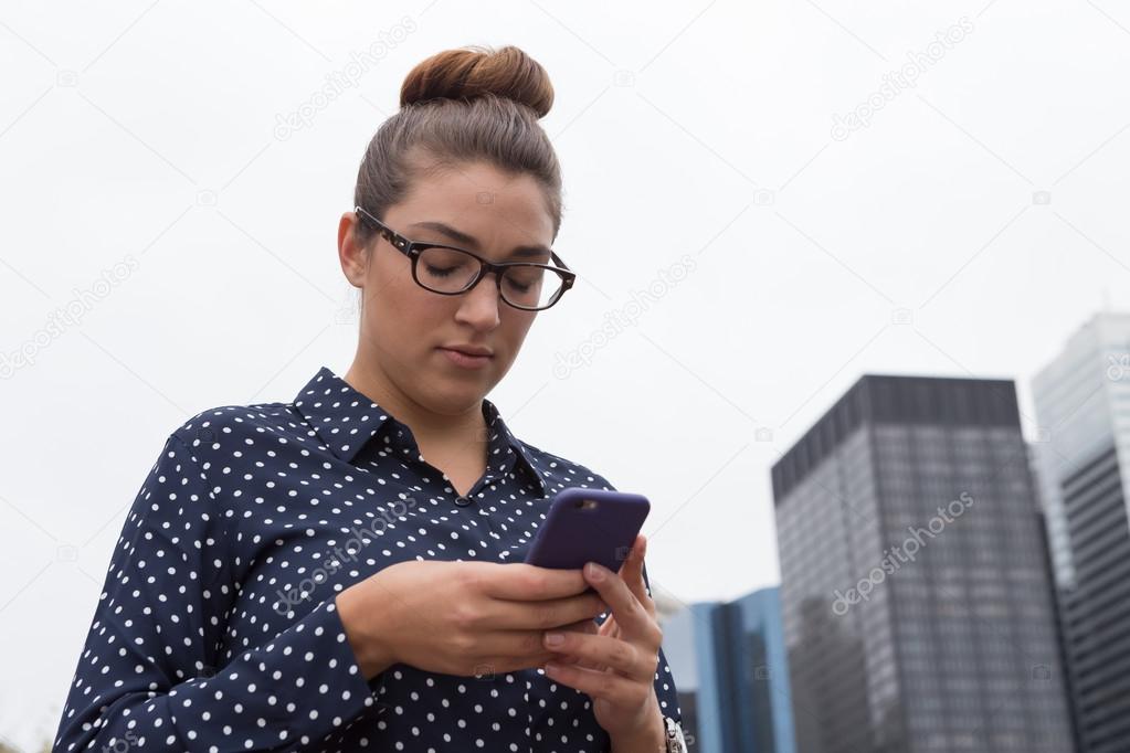 Young professional woman texting in the city