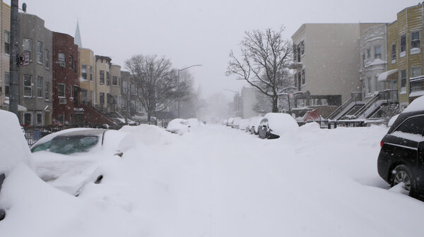 Residential street hit by snowstorm and covered by snow. Photographed in Brooklyn NY on January 23rd, 2016.