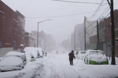 Woman walk along snow covered street clipart