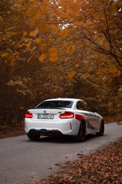 Kyiv, Ukrayna - Eylül 2020. BMW M2 F87 Sonbahar Ormanı 'nda beyaz renkli bir yarışma.