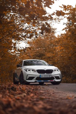 Kyiv, Ukrayna - Eylül 2020. BMW M2 F87 Sonbahar Ormanı 'nda beyaz renkli bir yarışma.