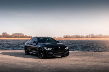 Kherson, Ukrayna - Mart 2019. BMW M4 F82 Irmağın arka planında siyah renkli bir yarışma.
