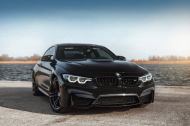 Kherson, Ukrayna - Mart 2019. BMW M4 F82 Irmağın arka planında siyah renkli bir yarışma.