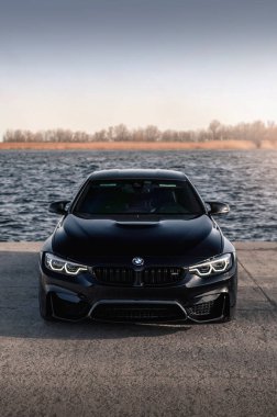 Kherson, Ukrayna - Mart 2019. BMW M4 F82 Irmağın arka planında siyah renkli bir yarışma.