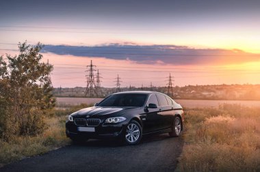 Kherson, Ukrayna - Haziran 2019. BMW 5 serisi F10 Güzel bir günbatımının arka planına karşı.