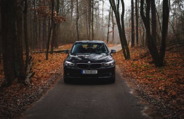 Kyiv, Ukrayna - Kasım 2019. BMW 3 serisi GT sonbahar orman yolunda siyah renkli.