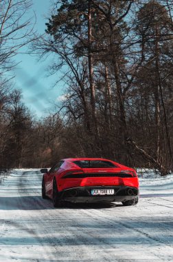 Kyiv, Ukrayna - Şubat 2020. Kızıl Lamborghini Huracan karlı ormanda.