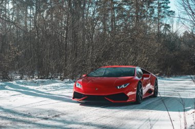 Kyiv, Ukrayna - Şubat 2020. Kızıl Lamborghini Huracan karlı ormanda.