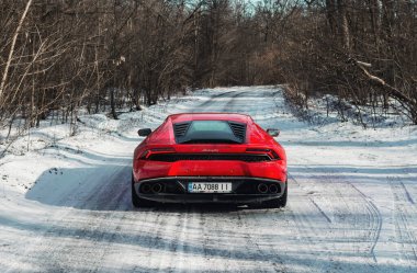Kyiv, Ukrayna - Şubat 2020. Kızıl Lamborghini Huracan karlı ormanda.