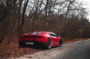  Kyiv, Ukrayna - Kasım 2019. İtalyan süper arabası Lamborghini Huracan sonbahar ormanlarında kırmızı renkte.