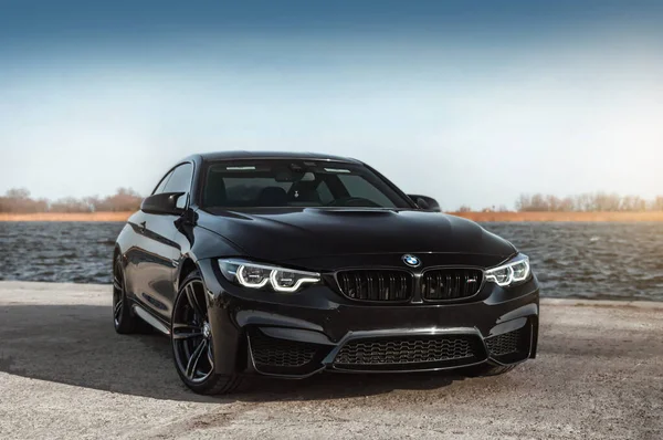 Kherson, Ukrayna - Mart 2019. BMW M4 F82 Irmağın arka planında siyah renkli bir yarışma.