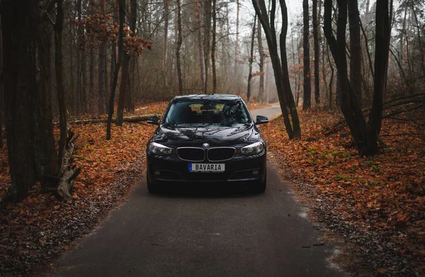 Kyiv, Ukrayna - Kasım 2019. BMW 3 serisi GT sonbahar orman yolunda siyah renkli.