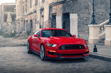 Odessa, Ukrayna - Ağustos 2020. Güçlü Amerikan kaslı arabası Ford Mustang GT 5.0 terk edilmiş kentsel binaların arka planında kırmızı bir renk..