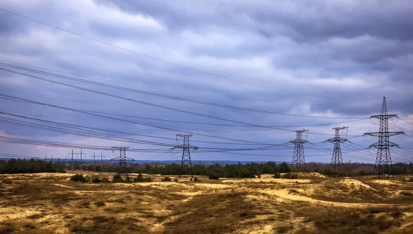 Высоковольтная линия электропередач в песке в штормовую погоду — стоковое фото