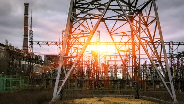 Електростанція з трансформаторами та лініями електропередач на заході сонця. верхній — стокове фото