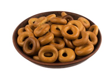 Beyaz arka plan üzerinde izole bir kil plaka üzerinde ev yapımı simit.