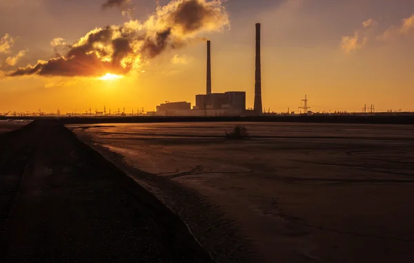 Завод з величезними димоходами на сході сонця. забруднення . — стокове фото