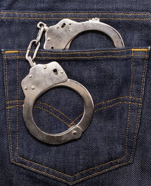 Police handcuffs in the back pocket of jeans — Stock Photo, Image