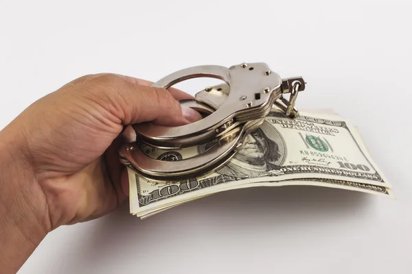 Взятка, ручная раздача долларов наручниками — стоковое фото