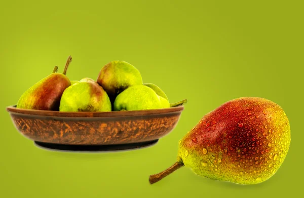 Päron med droppar av dagg och päron på keramik på en grön ba — Stockfoto