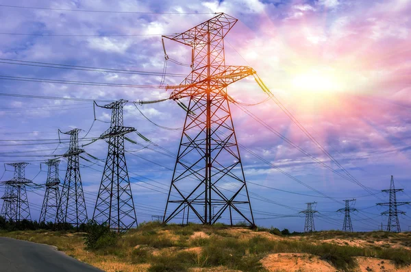 Yüksek voltajlı elektrik hatları gökyüzü güneş ile karşı