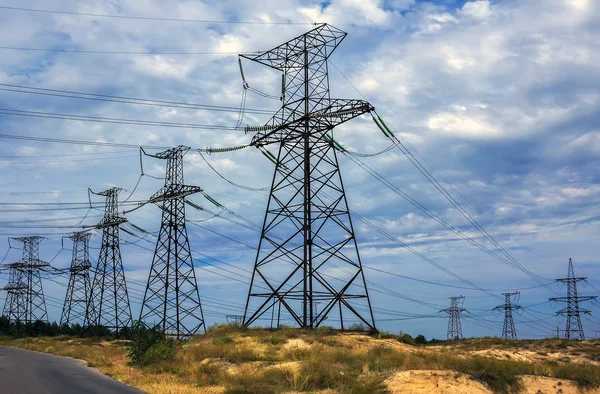 Высоковольтные линии электропередач на фоне грозовых облаков — стоковое фото