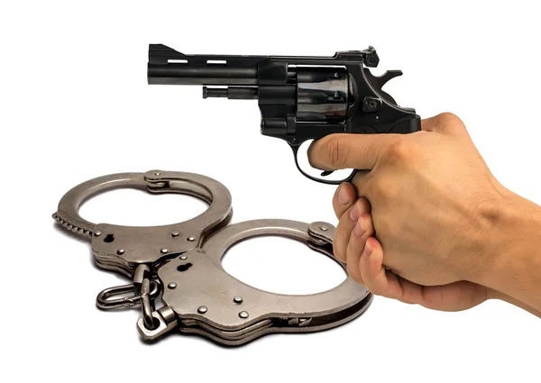 Pistol in hand on background police handcuffs. concept of justic — Stock Photo, Image