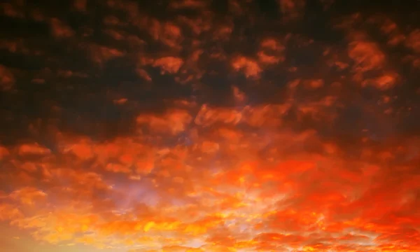 Pocked fiery sky at sunset with sun rays — Stock Photo, Image