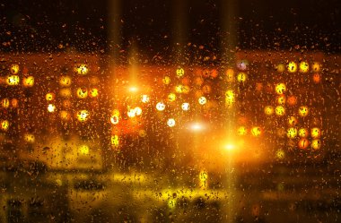 Sonra yağmur, bulanık ışıkları ile pencere camına su damlaları 