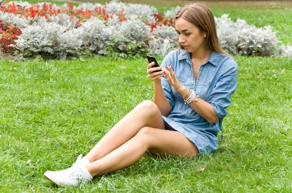Meisje met mobiele telefoon op aard — Stockfoto