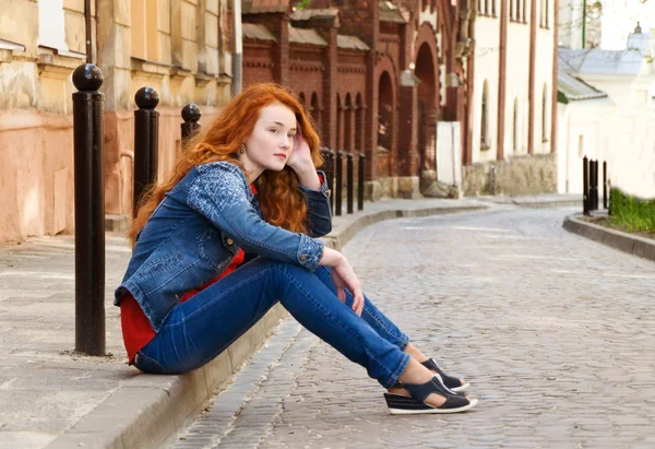 Solitario ragazza turista si siede sul marciapiede lungo — Foto Stock