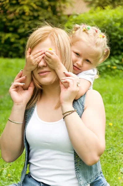 Moeder en dochter in de natuur. dochter haar moeders ogen gesloten — Stockfoto