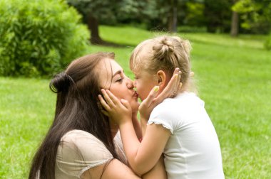 Aile doğada vakit geçiriyor. kızı yavaşça anne kisses