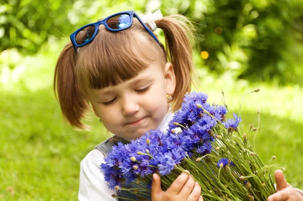 Liten flicka som håller en bukett blommor — Stockfoto
