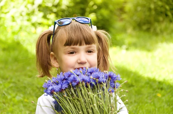 Liten flicka som håller en bukett blommor — Stockfoto