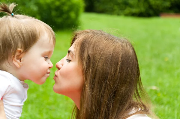 Familia pasa tiempo en la naturaleza. madre tiernamente besando hija — Foto de Stock