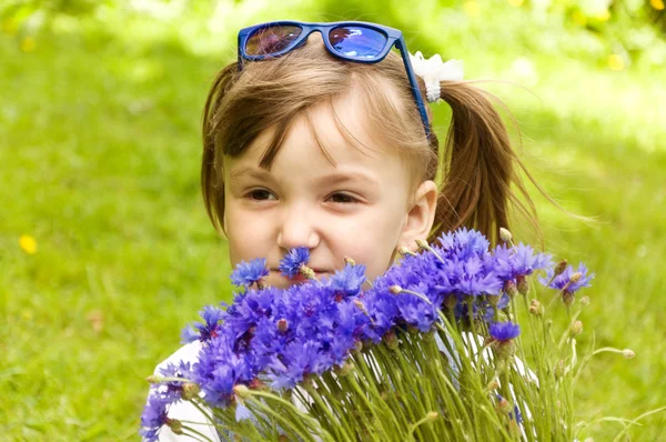 Liten flicka som håller en bukett blommor — Stockfoto