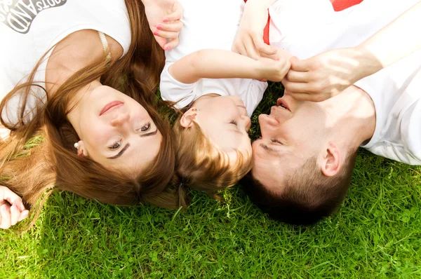 Mamá y papá beso mejillas su hija — Foto de Stock