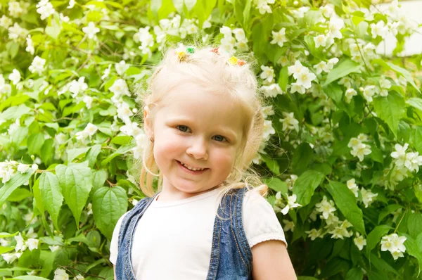Маленька дівчинка стоїть з білими квітами — стокове фото