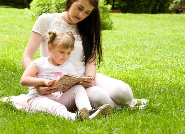 Mamá e hija leyendo un libro juntas — Foto de Stock